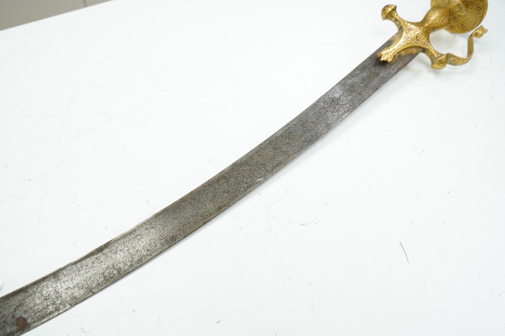 A good Indian sword tulwar, with 19th century broad curved single edge blade and iron hilt of conventional form entirely covered with flowering foliage